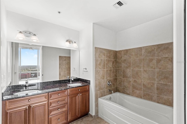 bathroom with tile patterned floors, vanity, and tiled shower / bath combo