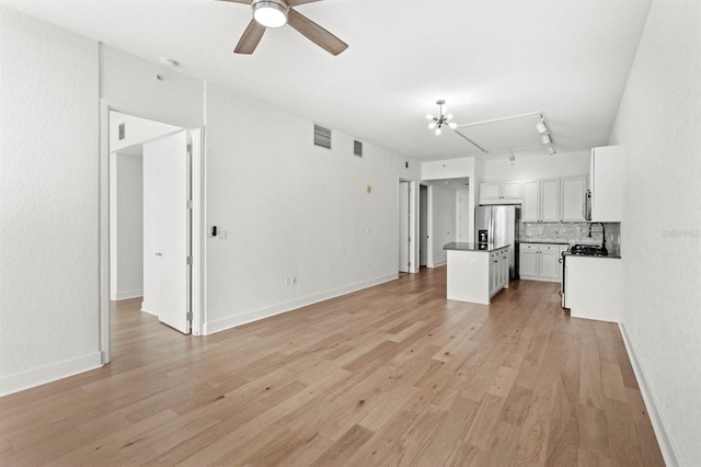 unfurnished living room with track lighting, light hardwood / wood-style floors, and ceiling fan with notable chandelier