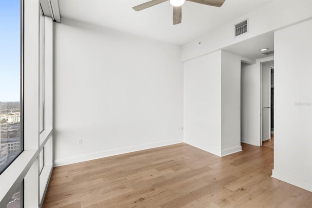 empty room with ceiling fan and light hardwood / wood-style floors