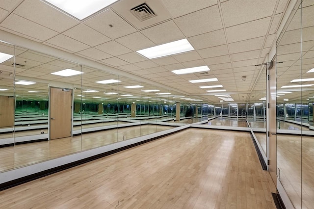 interior space with a paneled ceiling and wood-type flooring