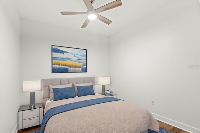 bedroom with dark hardwood / wood-style flooring and ceiling fan