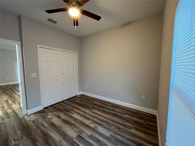 unfurnished bedroom featuring ceiling fan, dark wood-type flooring, and a closet