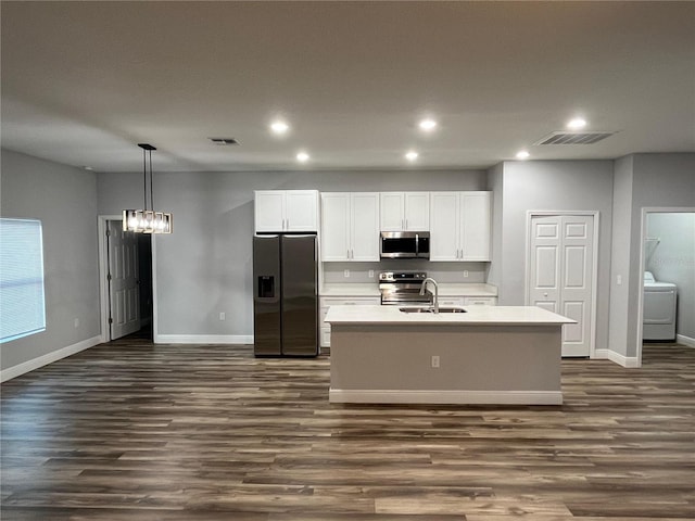 kitchen featuring dark hardwood / wood-style flooring, stainless steel appliances, and an island with sink