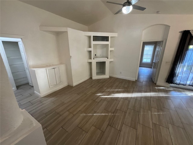 unfurnished living room with dark hardwood / wood-style floors, ceiling fan, and vaulted ceiling