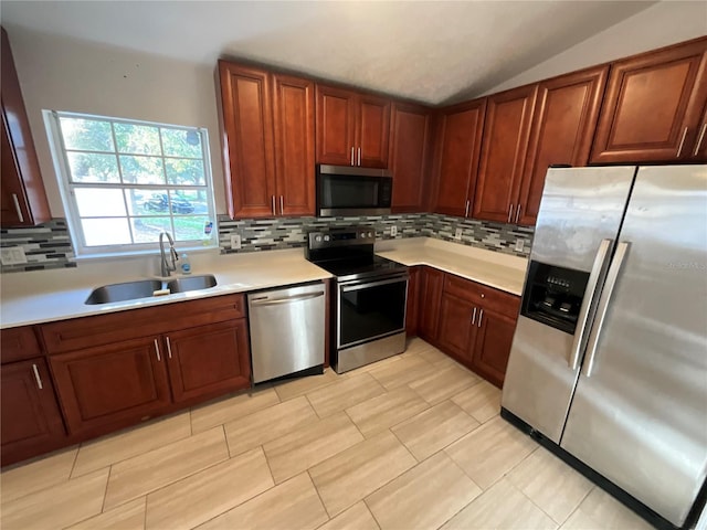 kitchen featuring tasteful backsplash, sink, appliances with stainless steel finishes, and vaulted ceiling