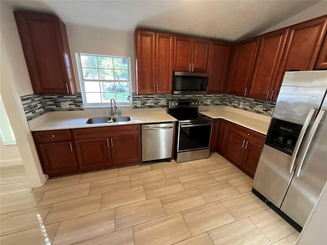 kitchen featuring backsplash, sink, stainless steel appliances, and vaulted ceiling