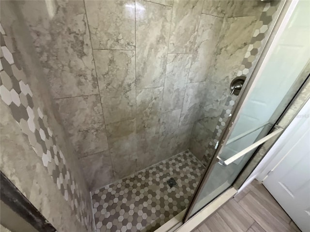 bathroom featuring hardwood / wood-style floors and tiled shower