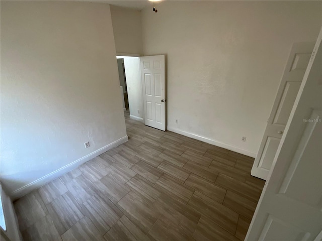 empty room featuring hardwood / wood-style floors and a towering ceiling