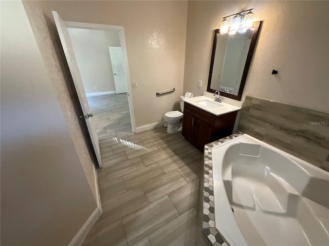 bathroom with hardwood / wood-style flooring, vanity, toilet, and a washtub