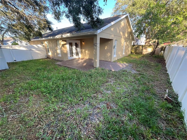 back of house featuring french doors, a yard, and a patio