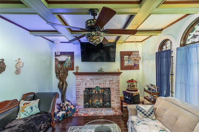 living room with ceiling fan, dark wood-type flooring, coffered ceiling, a fireplace, and ornamental molding