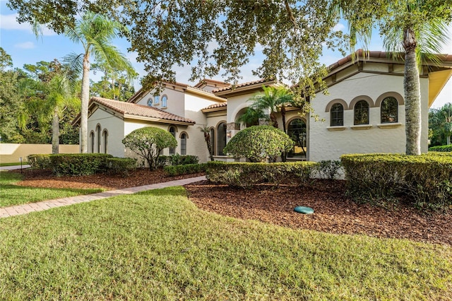 mediterranean / spanish-style house with a front lawn