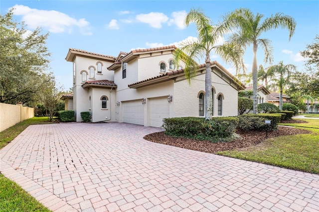 mediterranean / spanish-style house with a garage