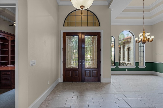 entryway with french doors, ceiling fan with notable chandelier, and ornamental molding