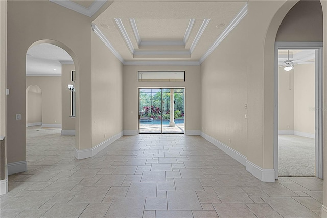 carpeted spare room featuring a tray ceiling, ceiling fan, and ornamental molding