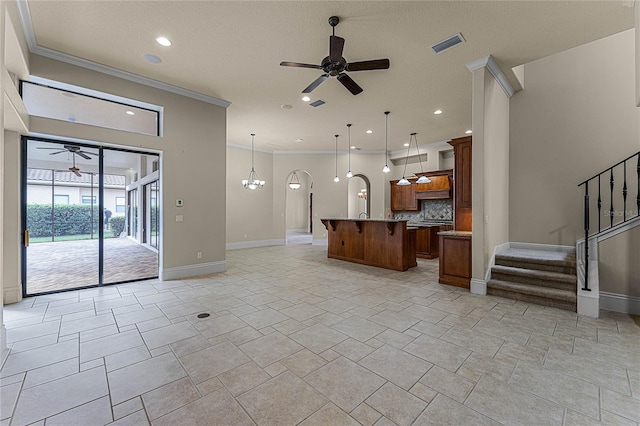 unfurnished living room featuring a textured ceiling, ornamental molding, and a notable chandelier