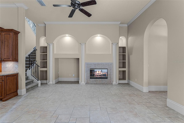 unfurnished living room with a tile fireplace, ceiling fan, and crown molding