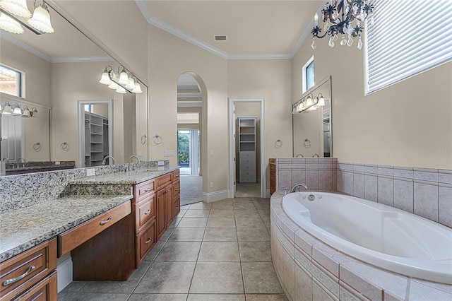 bathroom featuring tile patterned floors, tiled bath, vanity, and ornamental molding