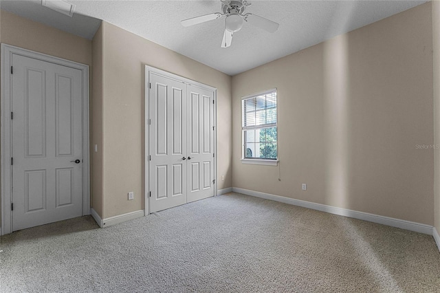 unfurnished bedroom featuring ceiling fan, light carpet, and a textured ceiling