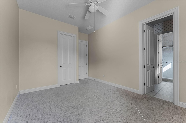 unfurnished bedroom with a textured ceiling, light colored carpet, and ceiling fan