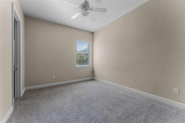 empty room with carpet flooring, ceiling fan, and a textured ceiling