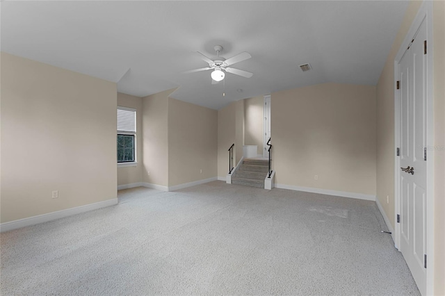 carpeted spare room featuring ceiling fan and vaulted ceiling