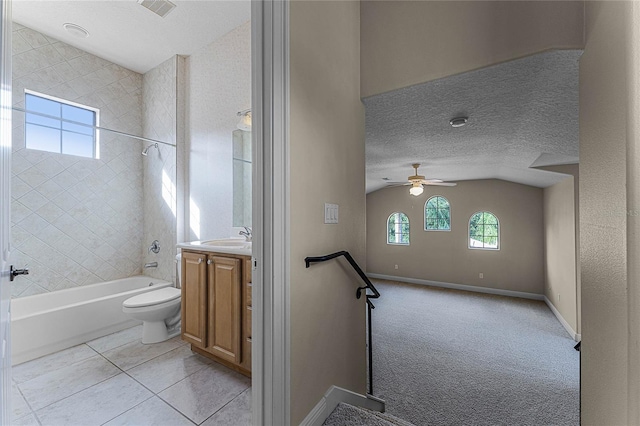 full bathroom featuring tile patterned floors, a textured ceiling, toilet, vanity, and tiled shower / bath