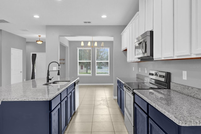 kitchen with blue cabinetry, appliances with stainless steel finishes, white cabinetry, and sink