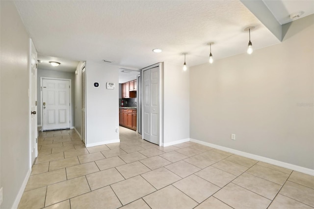 unfurnished room with light tile patterned floors and a textured ceiling