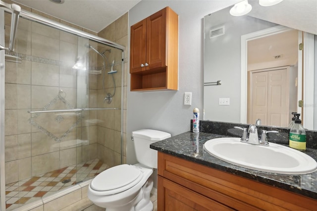 bathroom with vanity, an enclosed shower, and toilet