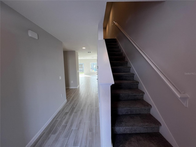 stairway with baseboards and wood finished floors