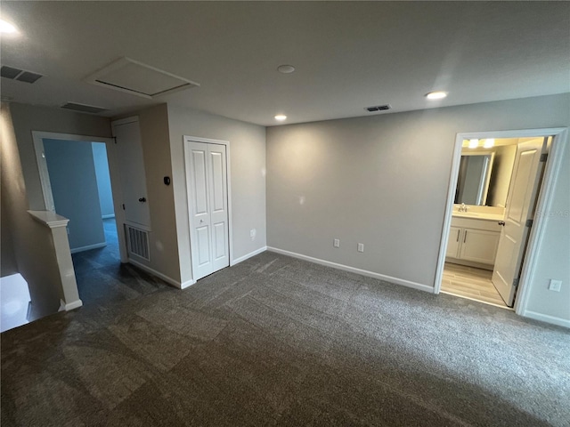 unfurnished bedroom with visible vents and dark carpet