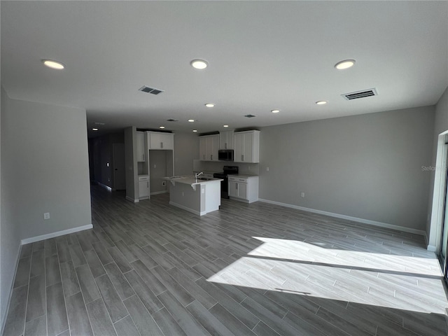 unfurnished living room featuring baseboards, recessed lighting, visible vents, and wood tiled floor