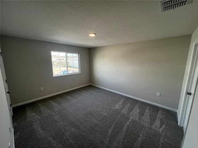 unfurnished bedroom with visible vents, dark carpet, a textured ceiling, and baseboards