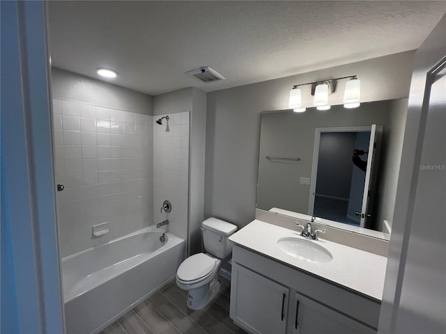 full bathroom with a textured ceiling, toilet, bathing tub / shower combination, vanity, and visible vents