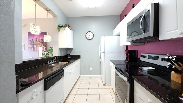 kitchen featuring sink, dark stone counters, decorative light fixtures, white cabinets, and appliances with stainless steel finishes