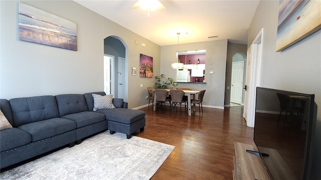 living room with ceiling fan and dark hardwood / wood-style flooring