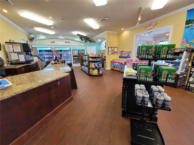 interior space featuring a textured ceiling, dark hardwood / wood-style flooring, and ornamental molding