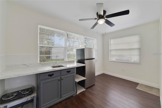 kitchen featuring stainless steel refrigerator, ceiling fan, sink, dark hardwood / wood-style floors, and gray cabinets