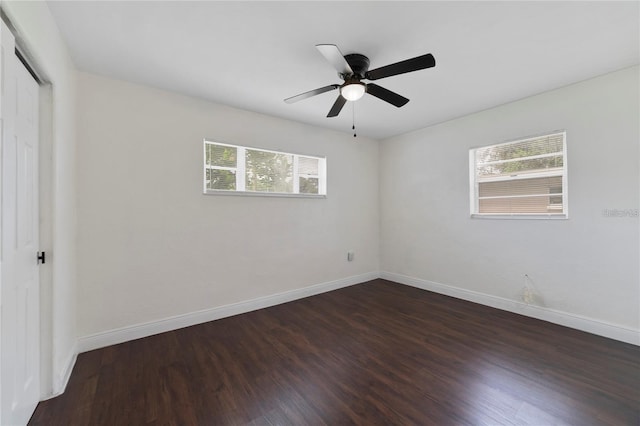 empty room featuring ceiling fan, plenty of natural light, and dark hardwood / wood-style floors