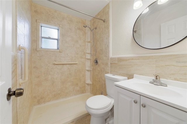 bathroom featuring tiled shower, vanity, toilet, and tile walls