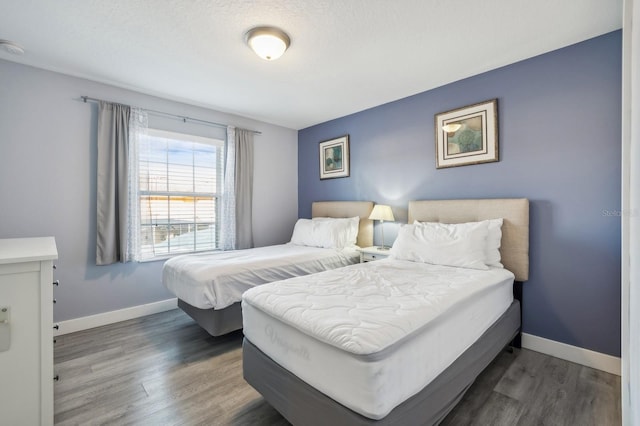 bedroom featuring a textured ceiling and dark hardwood / wood-style floors