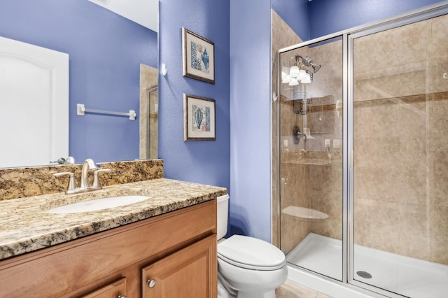 bathroom featuring vanity, toilet, and walk in shower