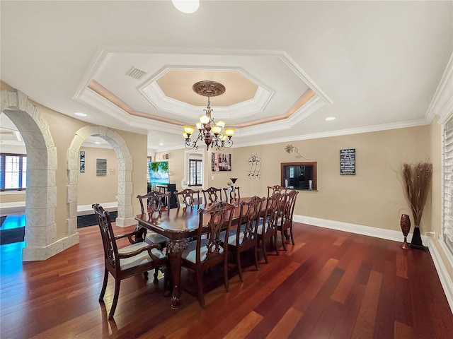 dining area with a chandelier, dark hardwood / wood-style flooring, crown molding, and a tray ceiling