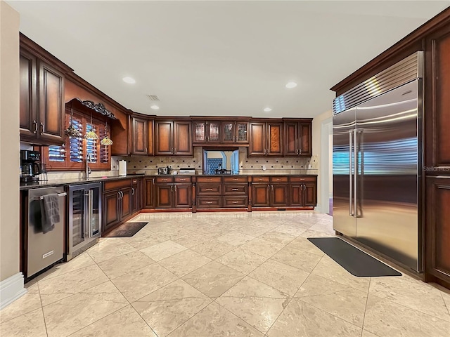 kitchen with decorative backsplash, sink, beverage cooler, and stainless steel appliances