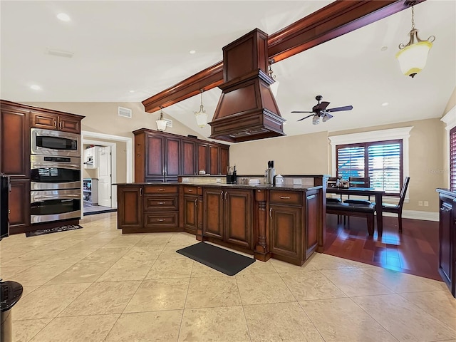 kitchen featuring dark stone counters, stainless steel appliances, ceiling fan, decorative light fixtures, and vaulted ceiling with beams