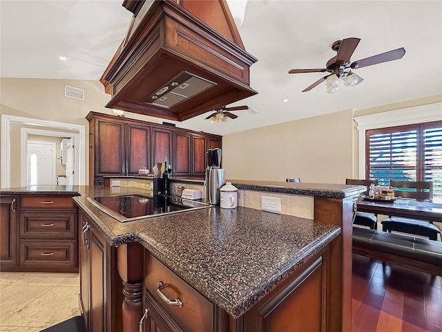 kitchen featuring a center island, vaulted ceiling, light tile patterned floors, black electric cooktop, and custom range hood