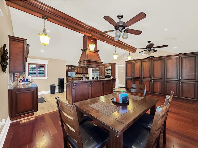 dining room with vaulted ceiling with beams, hardwood / wood-style flooring, ceiling fan, and sink