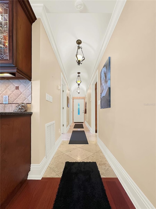 hallway featuring crown molding and light tile patterned floors