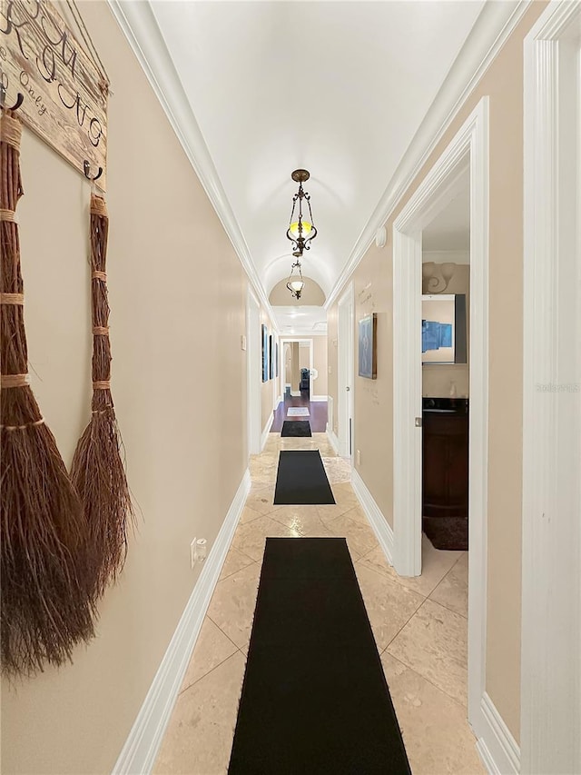 hallway featuring ornamental molding and light tile patterned floors